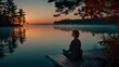 © Natalia S. - Serene silhouette of a woman meditating alone on a dock by a still lake during sunse. Mindfulness, solitude, reflection and spiritual calmness, mental health. Wellness and meditation