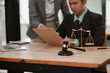 © aekachai - Group of lawyers and businesspeople meet in an office.