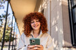 © Westend61 - Student with curly red hair using smartphone on university campus