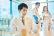 © Dialogue Frame - Young Asian Men and Women Scientists Collaborating in Modern Laboratory