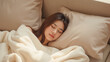© Oran - Peaceful young woman is sleeping comfortably soft blanket cozy couch, surrounded by plush pillows. serene atmosphere evokes sense of tranquility