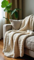 Wall Mural - Cozy living room scene featuring a soft, plush blanket draped over a comfortable sofa, adding warmth and texture to the home , hygge, home decor
