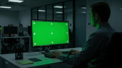 Developer Utilizing Green Screen Computer for Virtual Collaboration in Modern Office