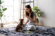 © Wasana - A woman sits on the floor with a small dog