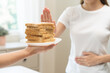 © KMPZZZ - Gluten allergy, asian young woman hand push out, refusing to eat white bread slice on plate in breakfast food meal at home, girl having a stomach ache. Gluten intolerant and Gluten free diet concept.