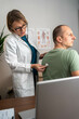 © Nenad - Female doctor using stethoscope to examine male patient's lungs and heartbeat during medical checkup in modern clinic, professional healthcare service