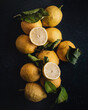 © ADDICTIVE STOCK - Fresh lemons with leaves on a dark background