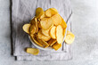© ADDICTIVE STOCK - Homemade potato chips in a bowl on a gray background