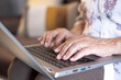 © luciano - Close up view of woman hands typing on keyboard of laptop holding laptop on his knees