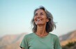 © Viktor - Outdoor portrait of a beautiful smiling middle aged woman looking up. Happy lady with grey hair enjoys sunny day at nature. Cheerful female, natural beauty, happy mature woman.