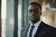 © Atlas Studio - Confident man in business attire stands by a window showcasing determination and professionalism