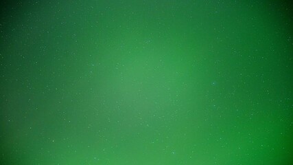 Wall Mural - timelapse looking up into a star filled sky colored shades of flashing green by northern lights
