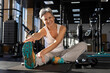 © kostikovanata - Athletic fitness elderly gray-haired woman stretching body at gym enjoy physical exercise activity.