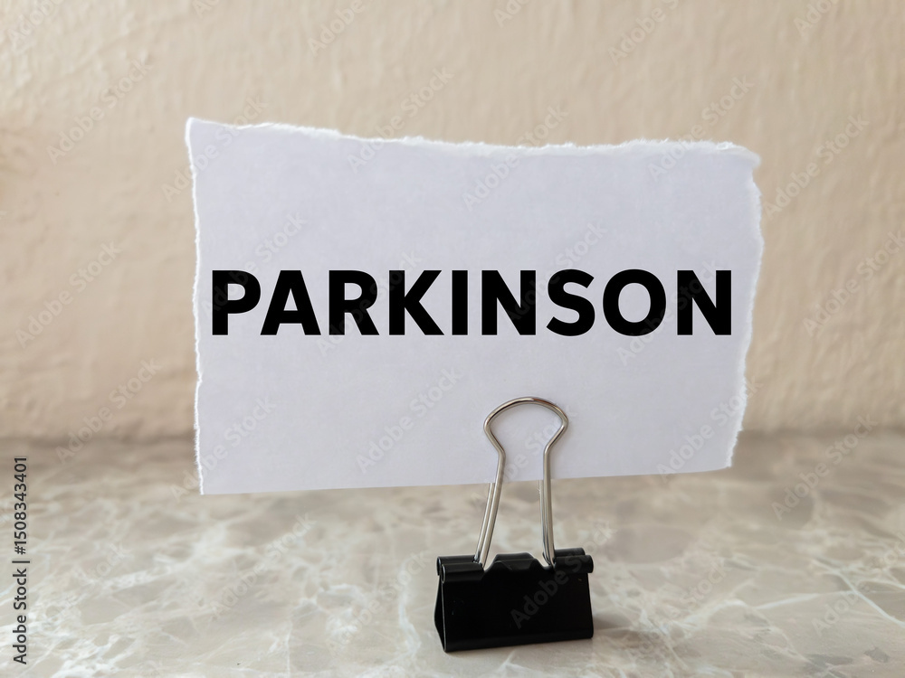 Parkinson message written on ripped torn white paper piece on wall ...