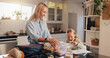 © peopleimages.com - Mother, kid and eating breakfast for school, nutrition and pack lunch box with sandwich. Parent, student and girl with food in kitchen for healthy diet, cereal and get ready with happy family in home
