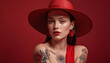 © Photo zone - Beautiful model of a girl shot at hip level, wearing a red dress, on a completely clear red background, art photo with hat. Advertising models for banners, posters, calendar