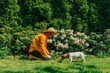 © VISTA by Westend61 - Man in a straw hat gardening with a Jack Russell Terrier in a lush garden