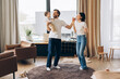 © Maria Vitkovska - Happy family dancing together in living room, happy parent concept