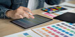 © Natee Meepian - Design Process. Creative designer using tablet for color selection and digital design.