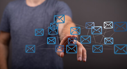 Man interacts with a network of email icons, symbolizing global communication and connectivity.