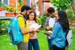 © StockImageFactory - Indian university classmates standing outdoors in garden, collaborating and sharing ideas together