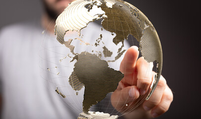 Fototapete - A hand interacts with a digital globe, symbolizing global connectivity and networking.