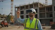© Aekion - Construction worker using VR headset inspects virtual designs at building site, ensuring precision and innovation for the new development project.