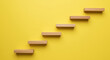© Neo GT - Wooden steps or stairs on yellow wall background concept of growth and achievement. Minimal yellow background