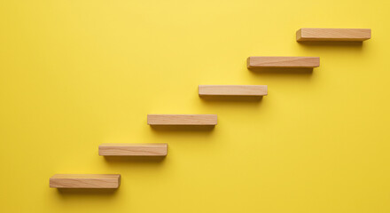 Wooden steps or stairs on yellow wall background concept of growth and achievement. Minimal yellow background
