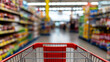 © StephanK - Close-up of Red Shopping Cart Handle in Supermarket Aisle with Blurred Shelves and Colorful Product Background – Retail and Grocery Store Concept