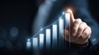© CStock - A professional hand pointing at a rising graph in a modern business setting.