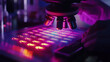 © Soulc - Scientist examining a microarray slide under a microscope in a laboratory setting with vibrant purple lighting.