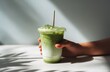 © AndiAzis - Iced matcha latte held in hand