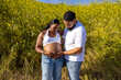 © Bogdan Pictures - An African American couple embraces the beauty of nature as the husband hugs his pregnant wifes belly, celebrating their upcoming journey into parenthood and the moments that await