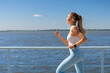© kostikovanata - Sport woman morning running jogging on city river embankment side view