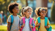 © alexander_volkov - Three children walk joyfully in a park on a sunny day, each with a colorful backpack. Their expressions show happiness and excitement as they engage with each other