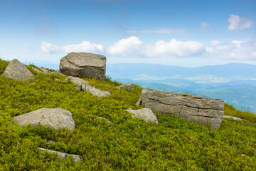 Wall Mural - boulder on a hill under blue sky with clouds in summer. huge sandstone among the grass. view in to t
