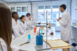 © alvaro - Chemistry teacher explaining lesson to students in laboratory