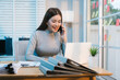 © Thitaporn - Asian woman diligently reviews paperwork at her softly lit desk late into the evening, overtime