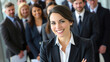 © Philipimage - Woman in a business suit is smiling and posing for a photo with a group of people. Concept of professionalism and confidence