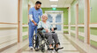 © Sergey - Elderly woman smiling in wheelchair being assisted in hospital corridor