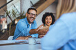 © Dragana Gordic - Diverse Professionals Smiling and Shaking Hands During a Business Interaction