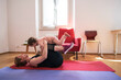 © Studio Marmellata - A happy mother and her young child are exercising together at home. They are lying on yoga mats, smiling and enjoying their fitness and bonding time.