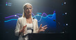 © Gorodenkoff - Tech Entrepreneur Talking Business Partnership and Venture Capital on Stage. Businesswoman Standing Behind a Podium Stand, Talking About Project Management and Finance at an International Event