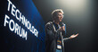 © Gorodenkoff - Startup Founder Talking About Business Partnerships and Collaborations on a Big Stage. Young Caucasian Man Talking About Future Technology Insights and Artificial Intelligence at a Global Event