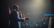 © Gorodenkoff - African Businessman Speaking at a Global Economic Strategies at International Business Conference. Public Speaker Sharing Professional Knowledge and Leadership Insights. Shot from Behind