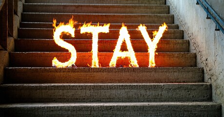 Leinwandbilder - Concrete steps display fiery word STAY. Dramatic lighting emphasizes text, creating intense visual impact. Dark background contrasts bright flames.