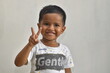 © Afdal - close up of 3 year old boy raising two fingers while smiling, on white background