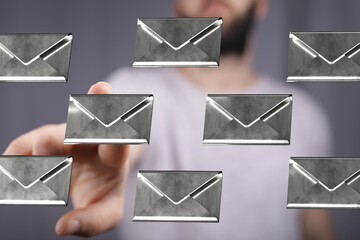 Leinwandbilder - Stock photo of a man's hand reaching towards multiple email icons, representing digital communication and inbox.