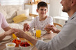 © New Africa - Family praying together before dinner at table indoors